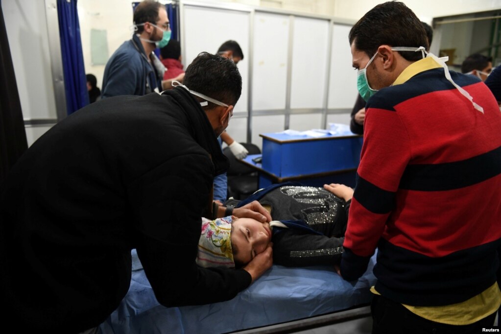 시리아 알레포에서 독가스로 추정되는 공격이 있은 후 의사가 독가스에 노출된 여성을 진단하고 있다.