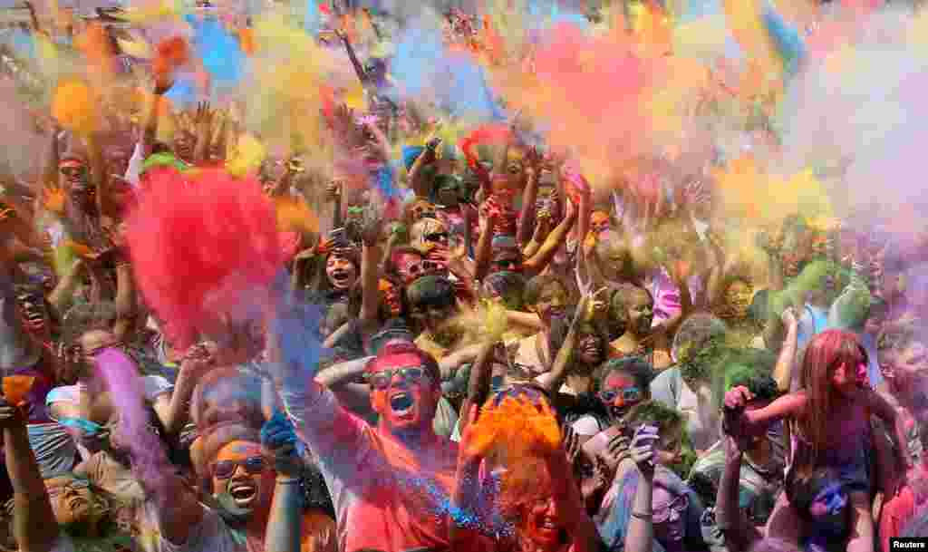 People throw colored powder during the Holi festival in Santa Coloma de Gramenet, near Barcelona, Spain.