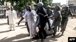 Security forces transport with a blanket the remains of some of the 11 victims of a double blast in the northern Cameroonian city of Maroua, July 22, 2015. 