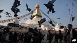 Burung merpati beterbangan di Stupa Boudhanath yang baru dibuka lagi untuk publik setelah restorasi pasca gempa di Kathmandu, Nepal (22/11). (AP/Niranjan Shrestha)