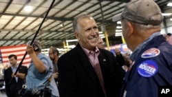 U.S. Senate candidate and Speaker of the N.C. House Thom Tillis speaks with a supporter during a conservative rally in Smithfield, N.C., Oct. 24, 2014.
