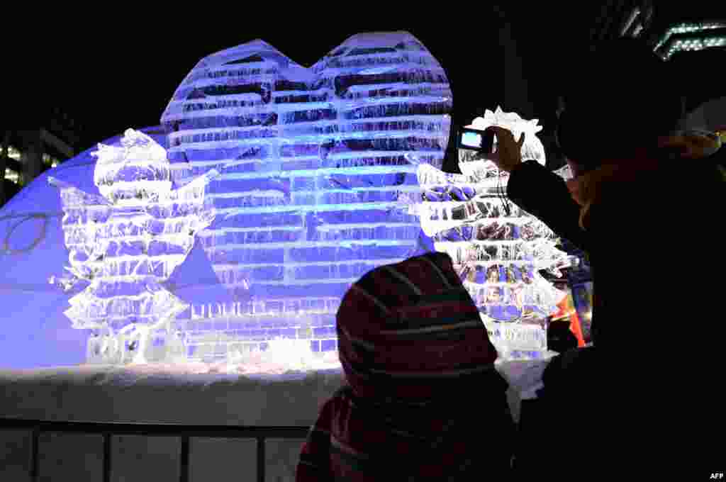 Visitors look at ice sculptures during the 65th annual Sapporo Snow Festival in Sapporo, Japan. The week-long festival started with a total of 198 snow statues on display and expects to attract around two million visitors.