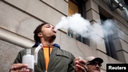 A man smokes as he waits in line for the opening of the Quebec Cannabis Society (SQDC) store, on the day Canada legalizes recreational marijuana, in Montreal, Quebec, Canada, Oct. 17, 2018. 