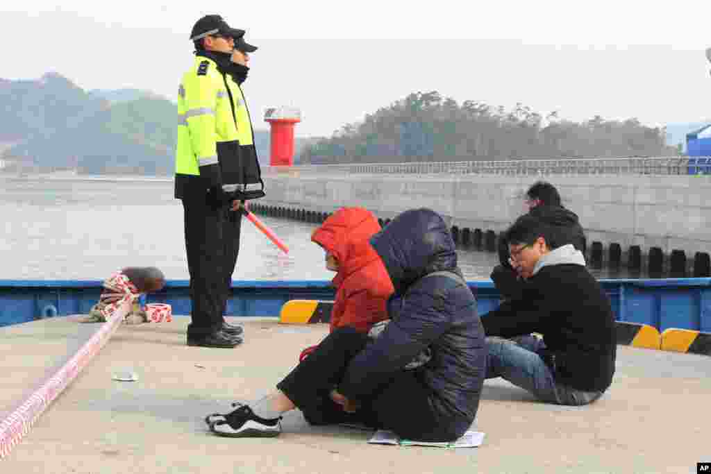 Thân nhân của hành khách trên chiếc phà bị chìm ngồi nhìn ra biển chờ tin về người thân bị mất tích tại cảng Jindo, ngày 22/4/2014.