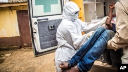 FILE- Health workers load a suspected Ebola patient into the back of an ambulance in Freetown, Sierra Leone, Sept. 24, 2014. 