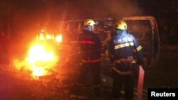 Firefighters try to extinguish a fire of a burning overturned police car in Luzhou, Sichuan province, October 17, 2012.