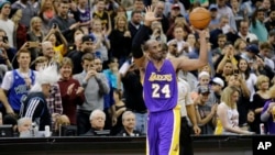 Pemain Los Angeles Lakers Kobe Bryant (24) mengangkat bola sambil menyapa penonton dalam pertandingan melawan Minnesota Timberwolves di Minneapolis (14/12). (AP/Ann Heisenfelt)
