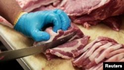 Seorang tukang daging menyiapkan daging babi di North Hills Meats di Toronto, Ontario, Kanada, 10 Mei 2017.