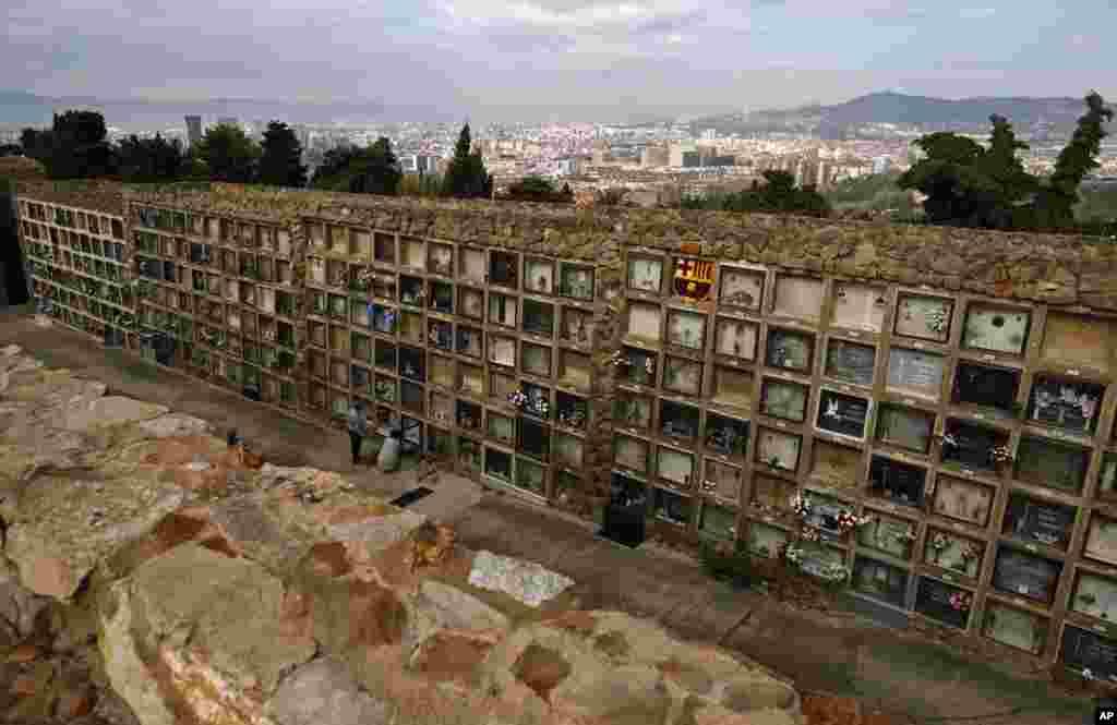 People clean a grave during All Saints Day, a Catholic holiday to reflect on the saints and deceased relatives, at the Montjuic cemetery in Barcelona, Spain.