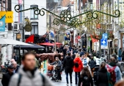 People do their Christmas shopping before the Dutch government's expected announcement of a "strict" Christmas lockdown to curb the spread of the Omicron coronavirus variant, in the city center of Nijmegen, Netherlands, Dec. 18, 2021.