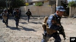 Iraqi security forces advance during fighting against Islamic State militants, in western Mosul, Iraq, March 6, 2017.