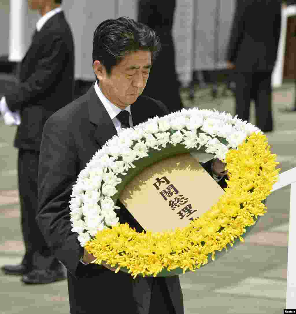 El primer ministro Shinzo Abe deposita una ofrenda floral en recuerdo de las víctimas de la bomba atómica de 1945, durante la ceremonia en el Parque de la Paz.