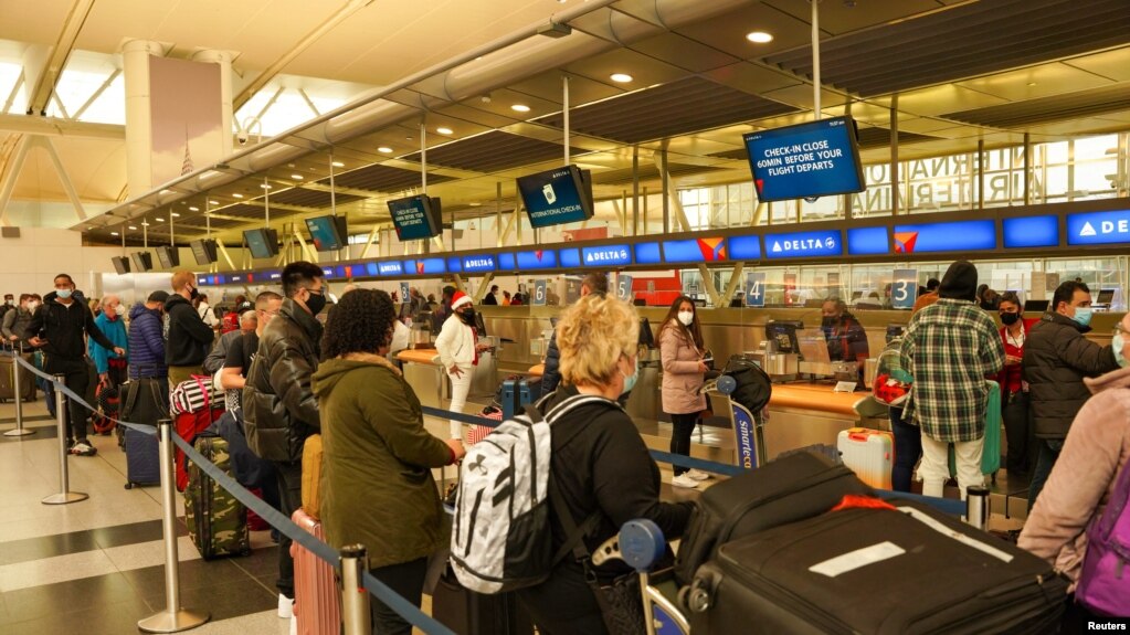 纽约肯尼迪国际机场的旅客平安夜之前排队办理乘机手续，但许多航班被宣布取消（2021年12月24日）(photo:VOA)