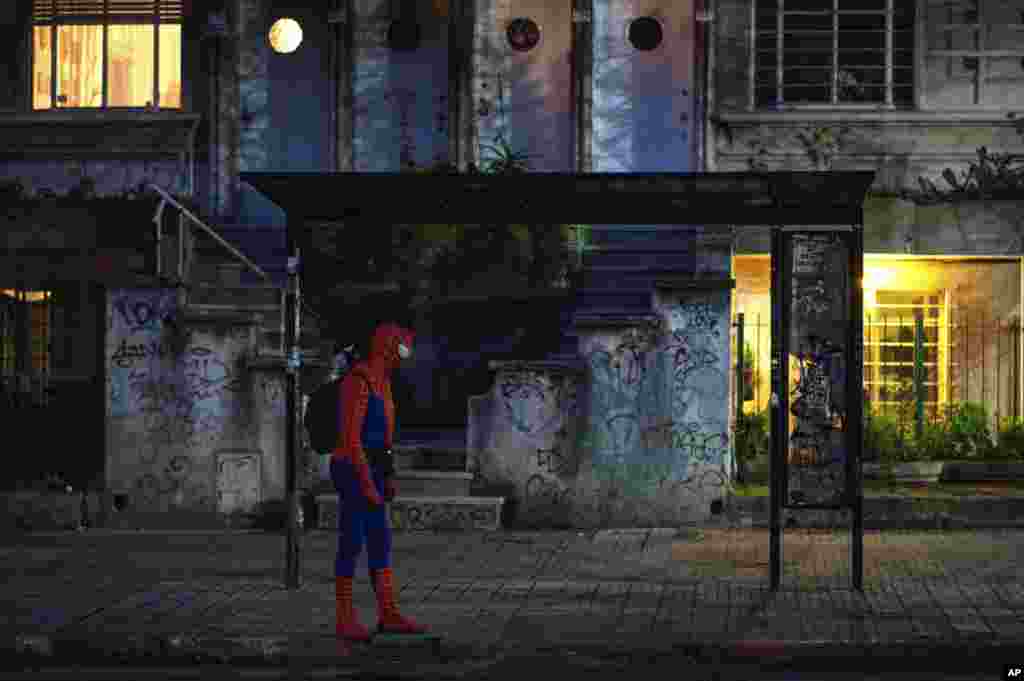 បុរសម្នាក់ស្លៀកពាក់ជា Spiderman រង់ចាំរថយន្តក្រុង ខណៈពេលមានការរាតត្បាតវីរុសកូរ៉ូណានៅក្រុងម៉ុងតេវីដេអូ ប្រទេសអ៊ុយរូហ្គាយ។