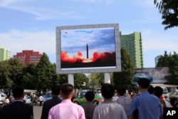 FILE - People watch a launching of a Hwasong-12 strategic ballistic rocket aired on a public TV screen at the Pyongyang Train Station in Pyongyang, North Korea, Sept. 16, 2017.