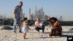 Freelance lifestyle photographer, Paula Hainey, takes photos of Darrin Chapman, a pilot recently laid off by long-haul carrier Emirates, his wife, Jodi Chapman, and their daughter Harper, in Dubai, United Arab Emirates, Wednesday, Oct. 14, 2020. Hainey is