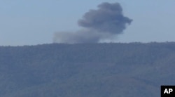 This frame grab from video by Haberturk TV, shows smoke from a Russian warplane after crashing on a hill as seen from Hatay province, Turkey, Nov. 24, 2015.
