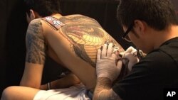 A tattoo artist at work during Ink Bomb 2011 in Seoul, South Korea