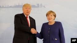 FILE - U.S. President Donald Trump and German Chancellor Angela Merkel pose for a photograph before a bilateral meeting on the eve of the G-20 summit in Hamburg, Germany, July 6, 2017. 