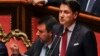 جوزپه کونته، نخست وزیر ایتالیا، در حال سخنرانی در پارلمان. متیو سالوینی کنار او نشسته است.