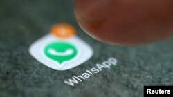 FILE - The WhatsApp app logo is seen on a smartphone in this picture illustration.