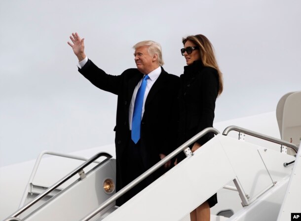 President-elect Donald Trump, accompanied by his wife Melania, waves as they arrive at Andrews Air Force Base, Maryland, Jan. 19, 2017.