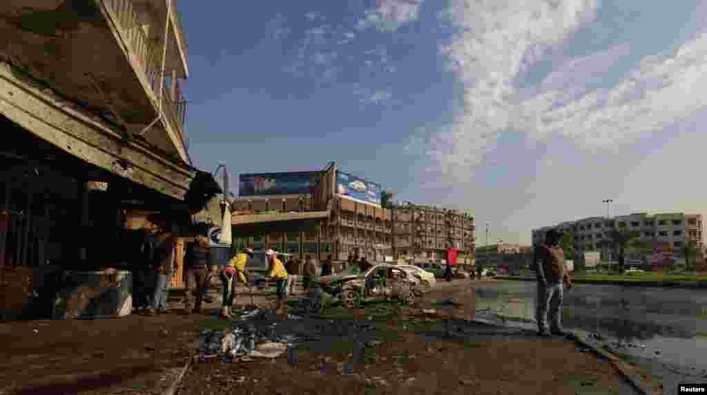 Municipality workers clean the site of a bomb attack in Baghdad, Jan. 15, 2014. 