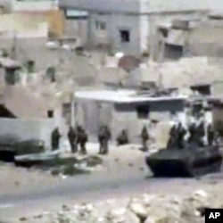Image taken from amateur video purports to show armored vehicles and troops taking up positions in Latakia on August 15, 2011. (The content and location of this image cannot be independently verified.)