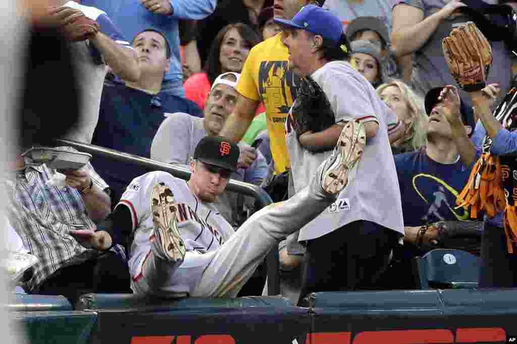 San Francisco Giants third baseman Matt Duffy tumbles into the stands after chasing in vain after a foul pop-up from Seattle Mariners&#39; Logan Morrison during the fifth inning of a baseball game in Seattle, Washington, USA, June 17, 2015.