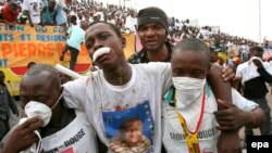 Des travailleurs de la croix rouge congolais portent un homme blessé lors des violences qui ont éclaté en marge d'un rassemblement électoral du candidat présidentiel Jean-Pierre Bemba à Kinshasa, RDC, 27 Juillet 2006. epa / NIC Bothma