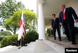 Japan's Prime Minister Shinzo Abe and U.S. President Donald Trump arrive for a joint news conference in the Rose Garden of the White House in Washington, June 7, 2018.