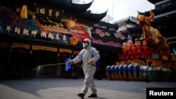 中国春节前上海豫园的一名工作人员在喷洒消毒水。（2021年1月27日）