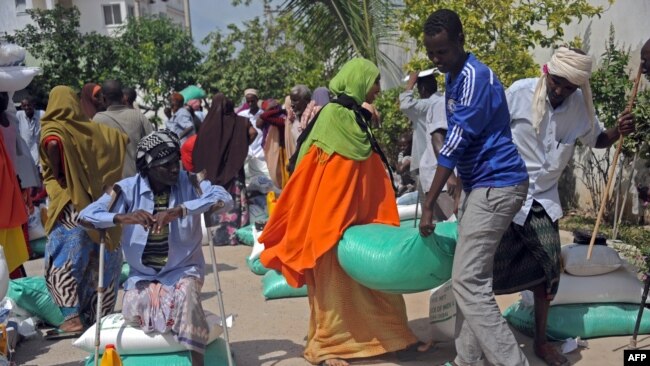 FILE - Somali internally displaced people receive food aid donated by a Qatari charity during the holy Muslim month of Ramadan in Mogadishu, June 20, 2015. Somalia's federal government has said it will stay neutral in Qatar's dispute with other Gulf Arab states.
