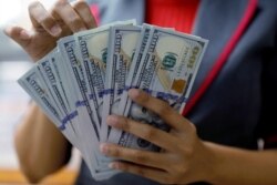 Seorang pegawai valas di perusahaan penukaran valas di Jakarta sedang menghitung uang dollar, 23 Oktober 2018. (Foto: Reuters)