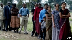 FILE - Members of a Kenyan family of Asian origin stand in line to cast their vote in Nairobi, Kenya, Dec. 27, 2007. On July 21, Kenya officially recognized Kenyan nationals of Asian descent as the country's 44th tribe. (AP Photo/Sayyid Azim)