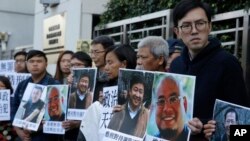 Pro-democracy activists hold pictures of Chinese activist Wu Gan, second right, and other activists outside the Chinese central government's liaison office in Hong Kong, Wednesday, Dec. 27, 2017. 