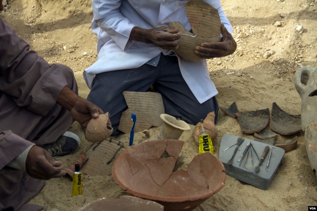 Egyptian excavation workers restore clay vessels with different shapes near a newly discovered tomb in the Draa Abul Naga necropolis on Luxor’s west bank, Egypt, Dec. 9, 2017. (H. Elrasam/VOA)