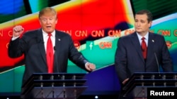FILE - Republican U.S. presidential candidate businessman Donald Trump (L) speaks as Senator Ted Cruz looks on during the Republican presidential debate in Las Vegas, Nevada, Dec. 15, 2015. 