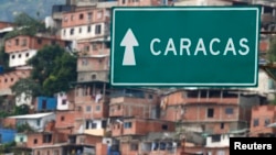 FILE - A road sign indicates the way to Caracas at Simon Bolivar international Airport in La Guaira, outside Caracas, Venezuela, July 10, 2013. 