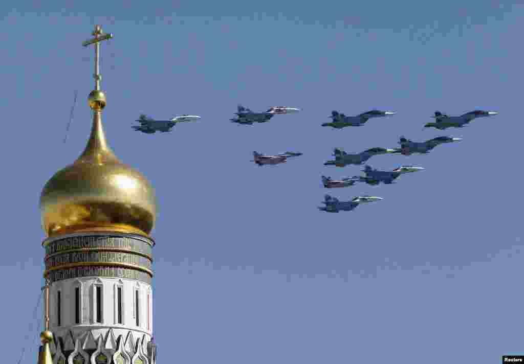 Pesawat militer Rusia terlihat terbang di atas udara Kremlin, di sekitar menara Ivan, The Great Bell, dalam perayaan Hari Kemenangan Rusia di Lapangan Merah, Moskow (9/5).