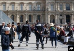 Police officers patrol outside the Louvre museum, April 21, 2017 in Paris.
