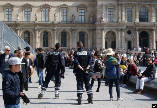 Police officers patrol outside the Louvre museum, April 21, 2017 in Paris.