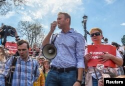 ຜູ້ນຳຝ່າຍຄ້ານ ຂອງຣັດເຊຍ ທ່ານ ອາເລັກຊີ ນາວາລນີ (Alexei Navalny) (ກາງ) ເຂົ້າຮ່ວມການຊຸມນຸມປະທ້ວງ ກ່ອນໜ້າ ພິທີສາບານໂຕ ເຂົ້າຮັບຕຳແໜ່ງປະທານາທິບໍດີ ຂອງທ່ານວລາດີເມຍ ປູຕິນ ທີ່ນະຄອນຫຼວງ ມົສກູ ຂອງຣັດເຊຍ, ວັນທີ 5 ພຶດສະພາ 2018.