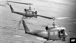 FILE - Soldiers of the U.S. 25th Infantry Division dangle their feet over the sides as they are transported by helicopter into an operational area in the Mekong Delta southwest of Saigon, Aug. 9, 1967. The unit was on a search and clear operation. 
