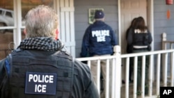 FILE - In this Feb. 9, 2017, photo provided U.S. Immigration and Customs Enforcement, ICE agents are at a home in Atlanta, Georgia, during a targeted enforcement operation aimed at immigration fugitives, re-entrants and at-large criminal aliens.