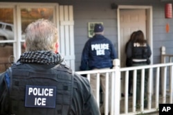FILE - In this Feb. 9, 2017, photo provided by U.S. Immigration and Customs Enforcement, ICE agents are seen at a home in Atlanta.