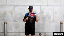 一名香港抗议者在英国驻港总领事馆外手举英国国旗。（2019年8月21日）