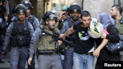 An Israeli policeman prevents a Palestinian man from entering the compound which houses al-Aqsa mosque, known by Muslims as the Noble Sanctuary and by Jews as the Temple Mount, in Jerusalem's Old City Sept. 28, 2015.