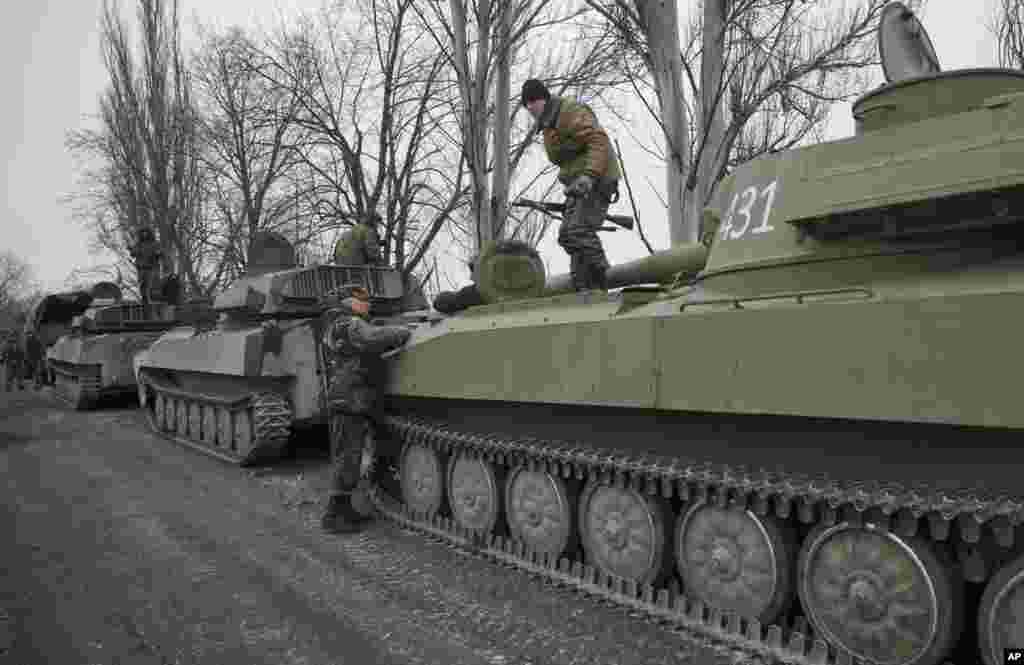 Russia-backed separatist fighters stand on self-propelled 152 mm artillery pieces, part of a unit that moved away from the front lines, in Yelenovka, near Donetsk, Ukraine, Feb. 26, 2015.