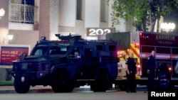 کیلی فورنیا کے شہر اورنج میں پولیس آفیسر اس عمارت کے سامنے تعینات ہیں، جہاں فائرنگ کا واقعہ پیش آیا۔ فوٹو رائٹرز